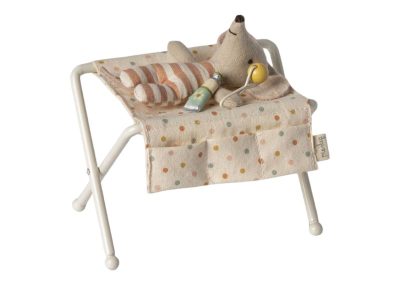 baby mouse on changing table with tube of lotion and rattle