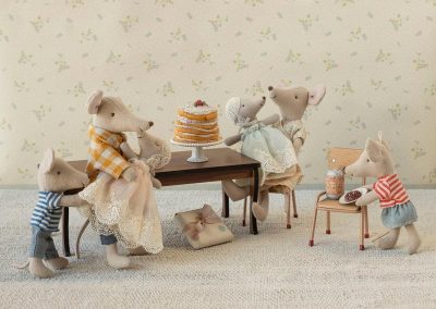 party scene with family around long dining table and birthday cake